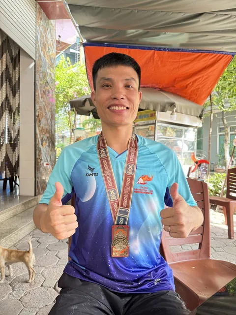 A finisher holding their X Challenge medal