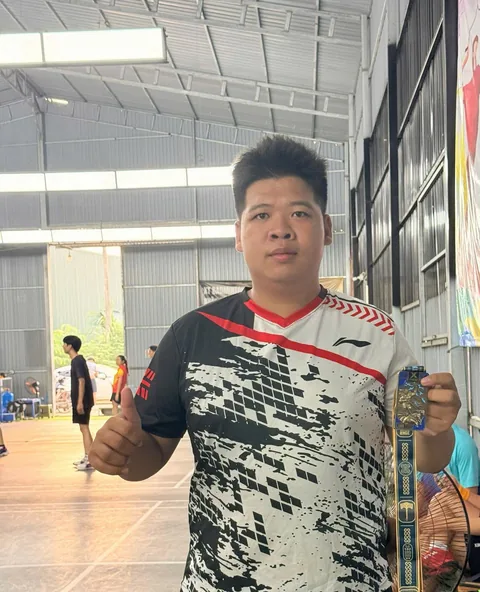 A finisher holding their X Challenge medal