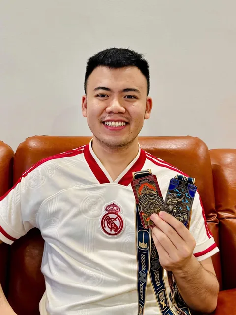A finisher holding their X Challenge medal