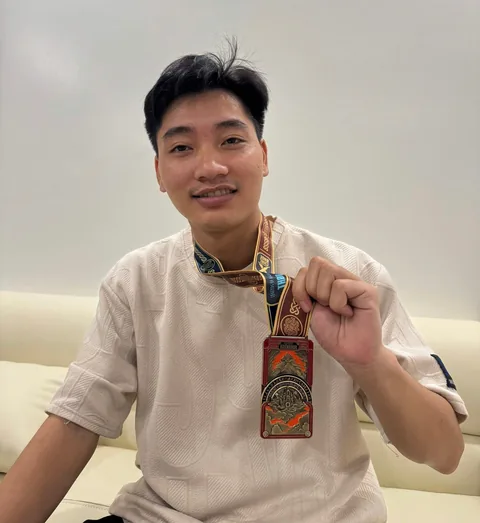A finisher holding their X Challenge medal