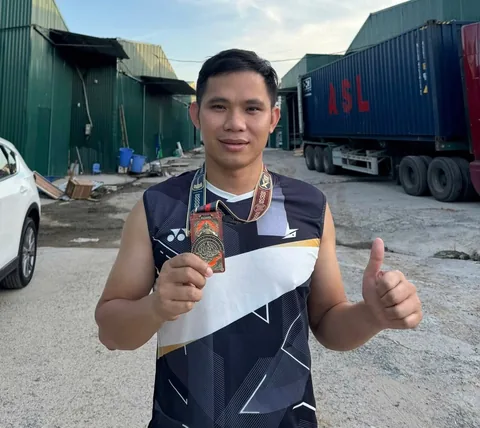 A finisher holding their X Challenge medal