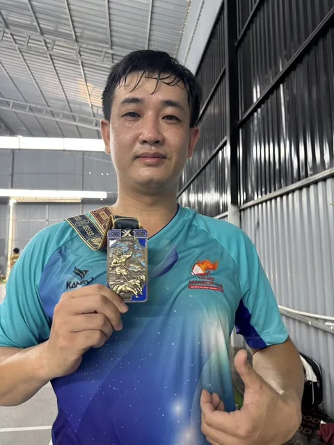 A finisher holding their X Challenge medal