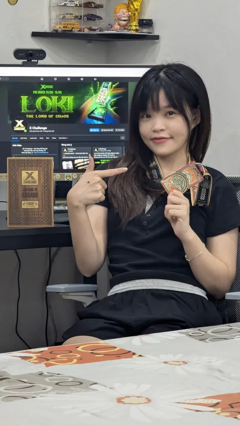A finisher holding their X Challenge medal