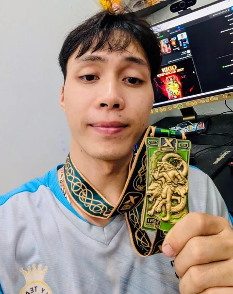 A finisher holding their X Challenge medal