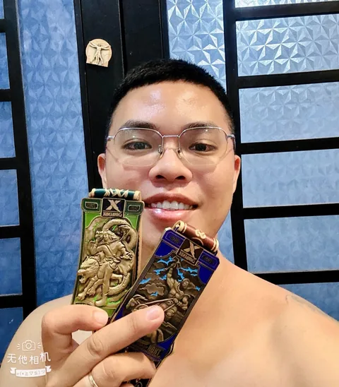 A finisher holding their X Challenge medal
